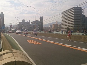 最終ランナー(今年も沖縄県）の後ろに白バイと救援車が